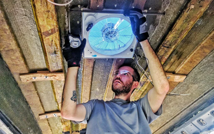 John installing a fan-tastic fan on their high top conversion van.