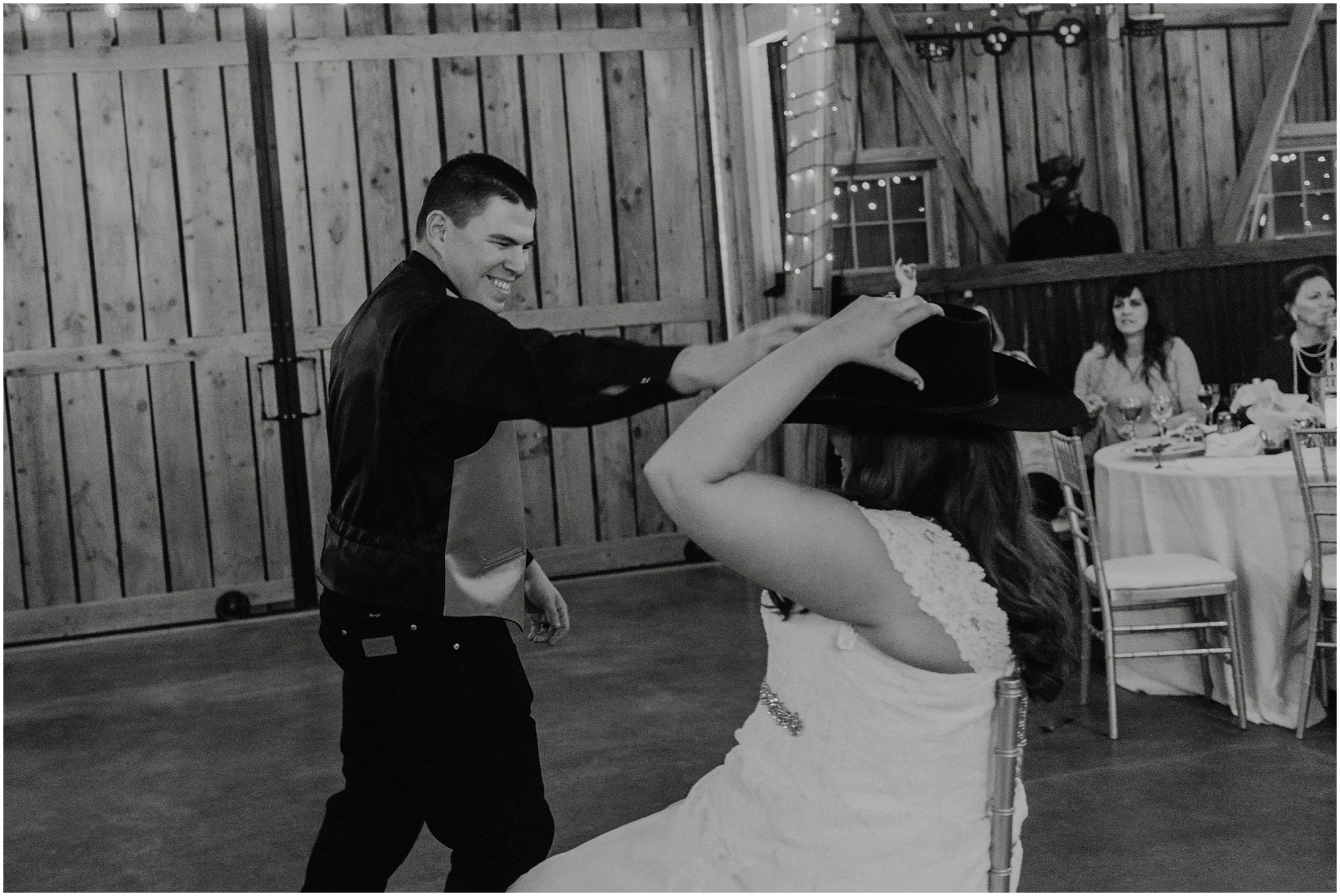 Groom places his cowboy hat on his bride during the garter toss.