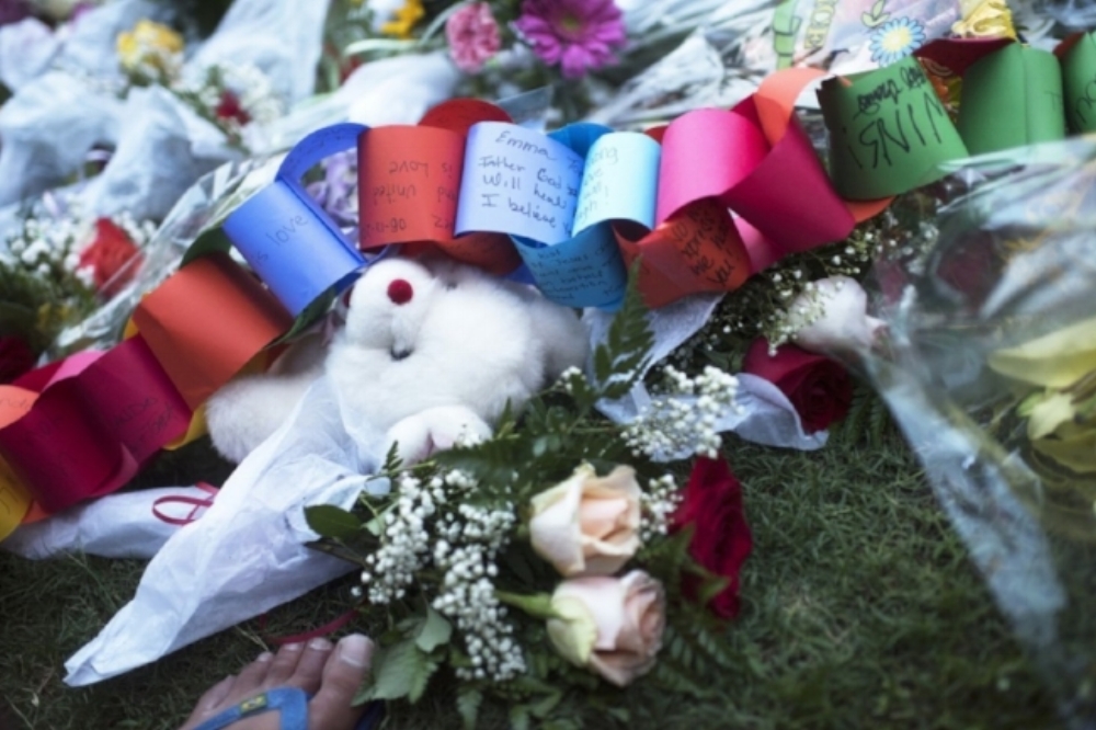 A teddy bear was among dozens of flowers left in honor of the deceased in Orlando. (Marvin Joseph/The Washington Post)