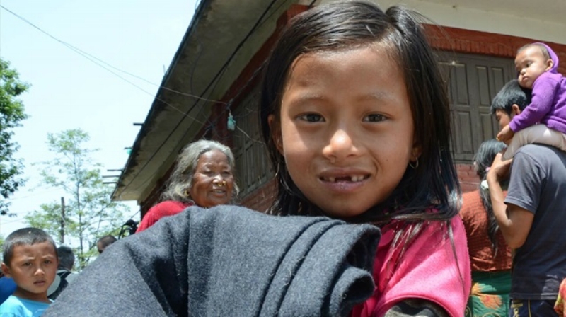 World Vision After the deadly April 25 quake in Nepal, a young survivor receives a blanket, distributed by World Vision.