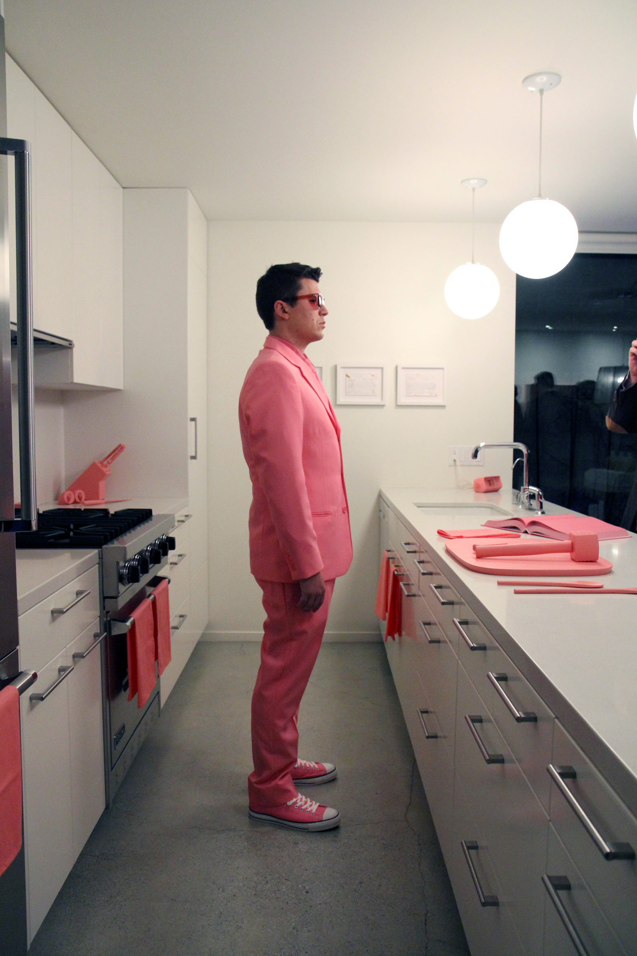   The Schauss Kitchen (Cooking)  Baker-Miller Pink painted kitchen objects, Baker-Miller Pink "cookbook," Baker-Miller Pink color therapy glasses, custom Baker-Miller Pink suit Installation dimensions variable, performance duration 15 minutes Marine 