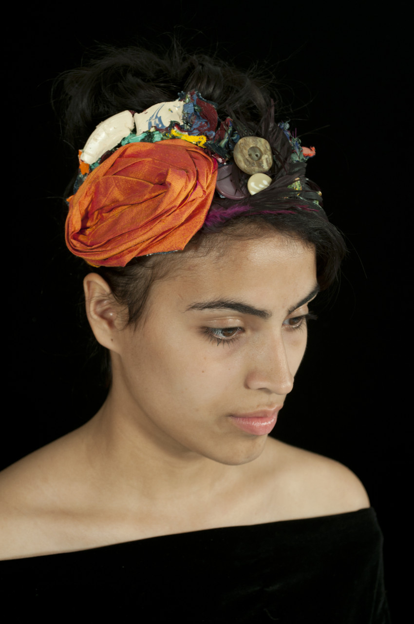 Materials: Repurposed polyester fabric, faux feathers, discarded dry acrylic paint, vintage buttons, and cotton fabric.