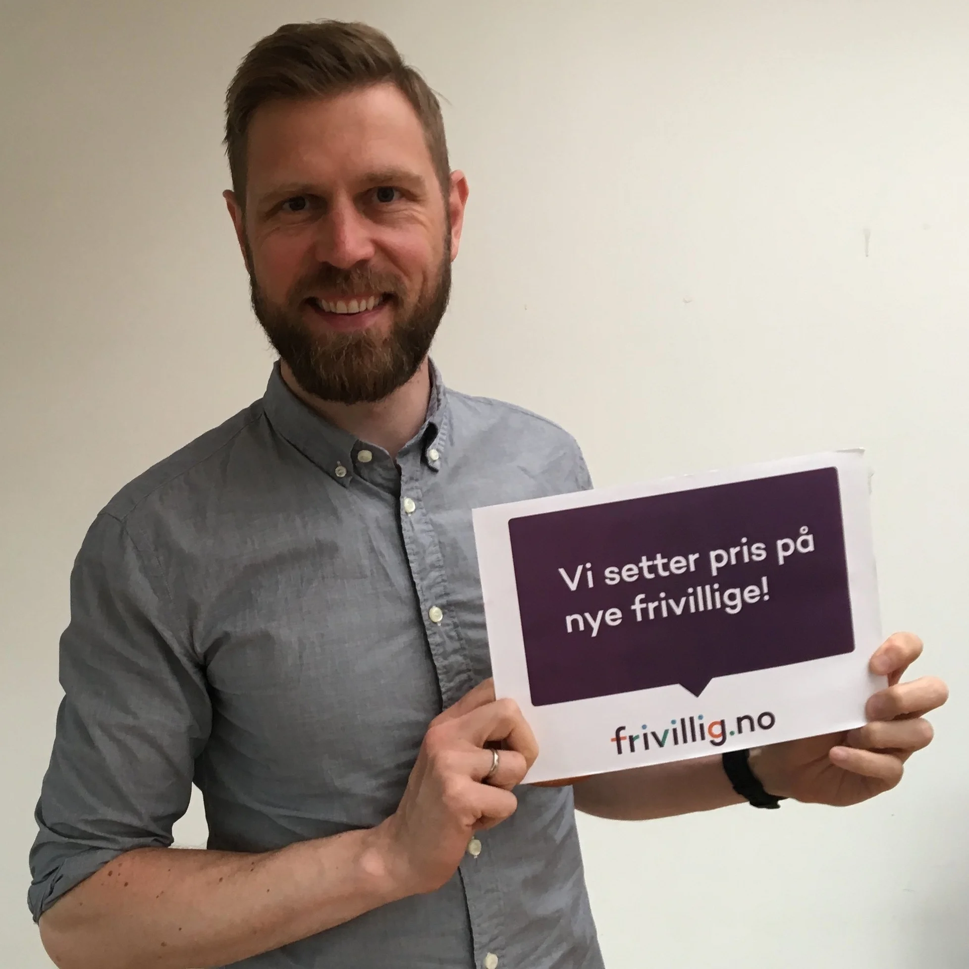 mann i grå skjorte med skjegg