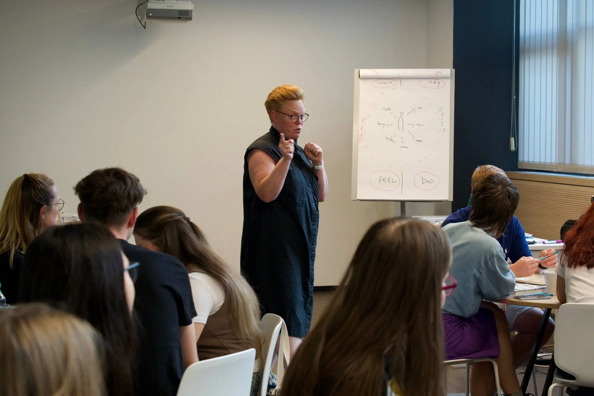 person står foran en samling mennesker og snakker