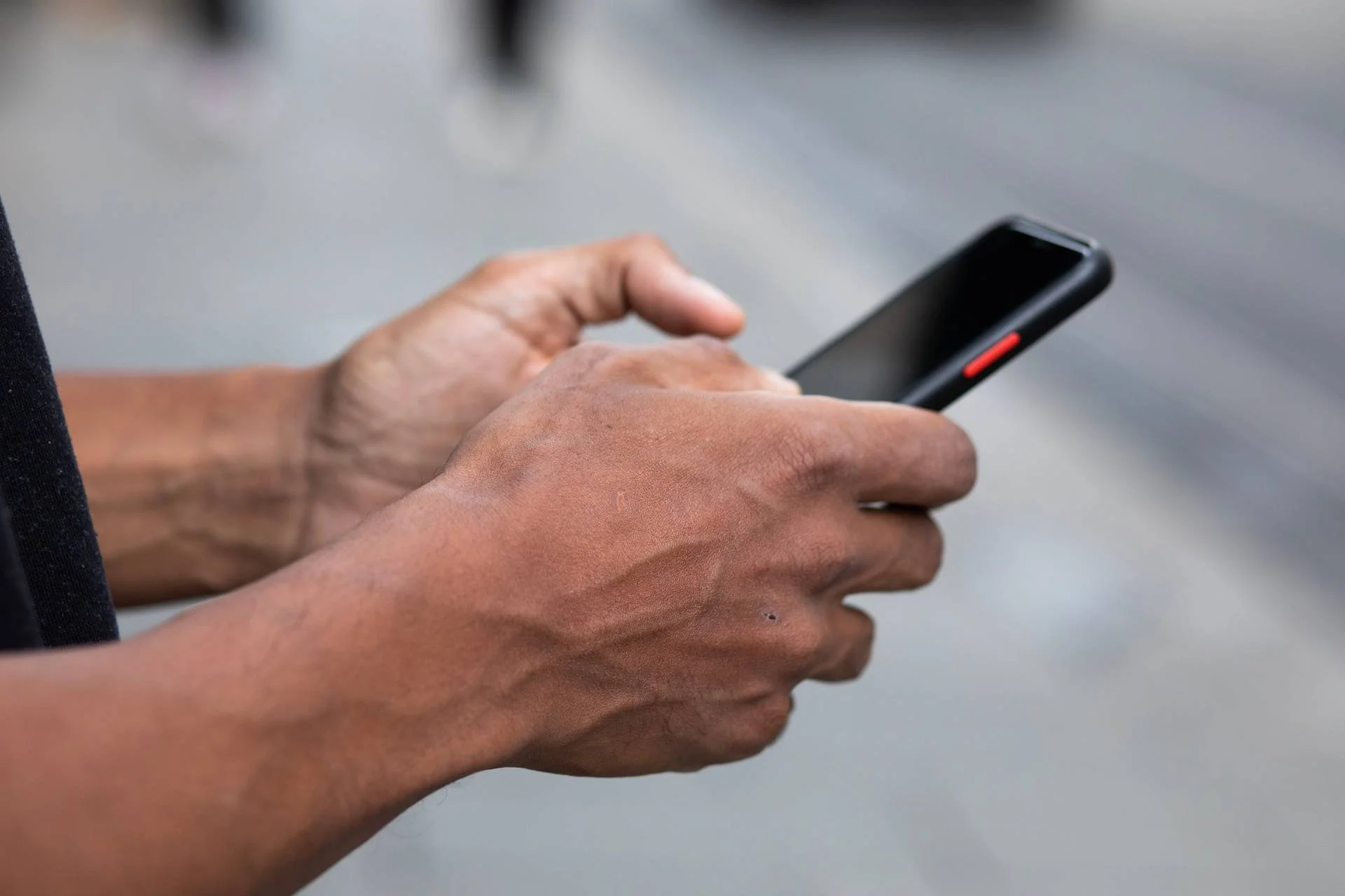 Hender holder i en mobiltelefon for å svare nye frivillige