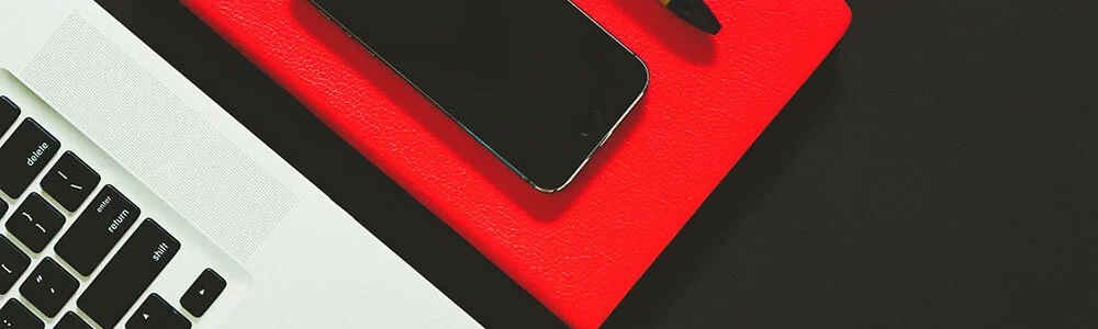 Computer, notebook, cellphone, and pen. Used to represent marketing consulting services.