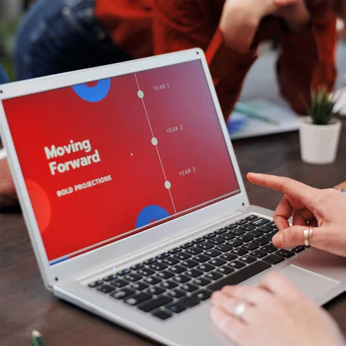 Person on laptop reviewing a Powerpoint of bold predictions for upcoming business years.