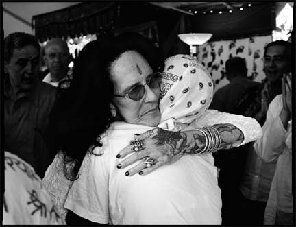 Guru Ma Jaya, Kashi Ashram – “I have had death drip all over me. If anyone can prove that one cannot get AIDS by kissing, hugging, just laying in the same bed and holding someone till they die, it would be me. But twenty years later, I still see the shuddering and fear of ‘Don’t touch me, you have AIDS.’” Guru Ma Jaya hugs a woman with AIDS at the ashram.