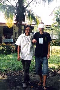 At a trust-building activity, Antonio, a Christian, guides Faisal, the blind-folded Muslim, around the community.