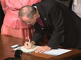 Bishop William Swing signing the URI Charter in 2000.