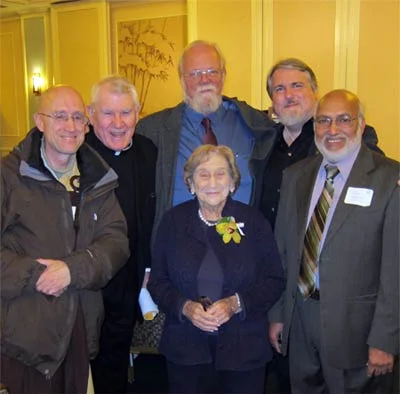 Five friends and interfaith colleagues surround Rita at her birthday celebration. From left, Rev. Heng Sure (Buddhist), Father Gerry O’Rourke (Catholic), Paul Andrews (Episcopalian), Elder Don Frew (Wiccan), and Iftekhar Hai (Muslim). All six have s…