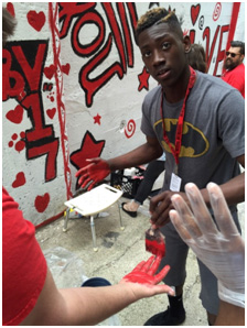 High-schoolers work with a local artist to paint a mural encouraging community members to take pride in their community and "Love Where You Live"