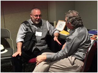 For many of the thousands who attend Parliaments, the most valuable experiences on the one-on-one, face-to-face communication these gatherings facilitate. Here Rabbi Rami Shapiro (left), author and host of How to Be a Holy Rascal, interviews Victor Kazangian, executive director of United Religions Initiative, in the URI hospitality suite. – Photo: TIO