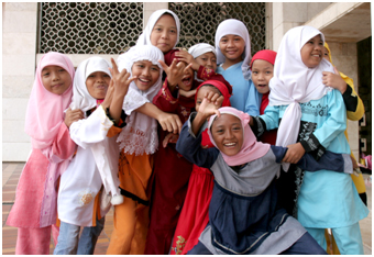 Muslim girls pose for the camera in front of the Istiqlal Mosque in Jakarta – Photo: Wikimedia Commons, Henrik Hansson