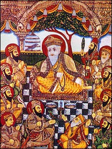 A 19th century painting of Guru Nanak in a circle of the 10 Gurus, with two friends at his feet, the one on the left a Muslim. – Photo: Wikipedia