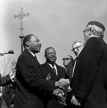 Dr. Martin Luther King, Jr. and Rabbi Abraham Heschel shaking hands at a march. – Photo: thegodface.blogspace.com