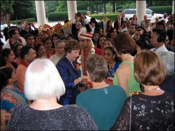 The mother of a Christian bride anoints her future Hindu son-in-law with sacred ash.