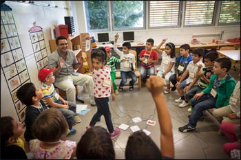 Timur Kumlu, left, with his first graders. “We must educate so that they develop a personality with common roots,” he said. Photo: Gordon Welters, The New York Times