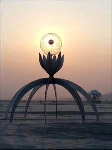 The sun sinks behind “Vision Quest,” the creation of Michael Hayward.