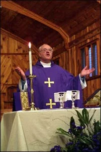 George Carey, former archbishop of Canterbury, celebrates Communion during a meeting of the Anglican primates in North Carolina in 2001. – Photo: James Rosenthal, Anglican Communion News Service