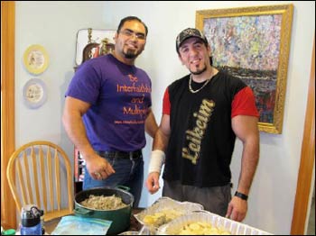 Tony (l.) and Ahmad pose in front of the Jordanian meal they’ve prepared.