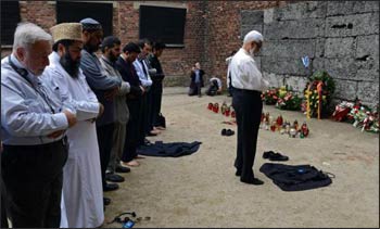 Muslim religious leaders from across the globe pray in front of so-called death wall at the Nazi death camp Auschwitz-Birkenau as part of an anti-genocide program on May 22, 2013. Muslim religious leaders from across the globe met with Holocaust survivors in an emotional encounter at Warsaw’s synagogue, as part of an anti-genocide program that includes a visit to Auschwitz. Photo: Janek Skarzynski, AFPO