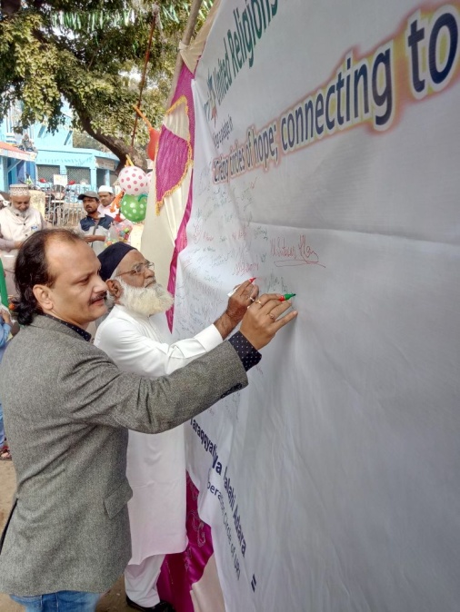 Biswadeb Chokraborty (l.) and a Muslim leader signing the pledge to support interfaith harmony. – Photo: URI