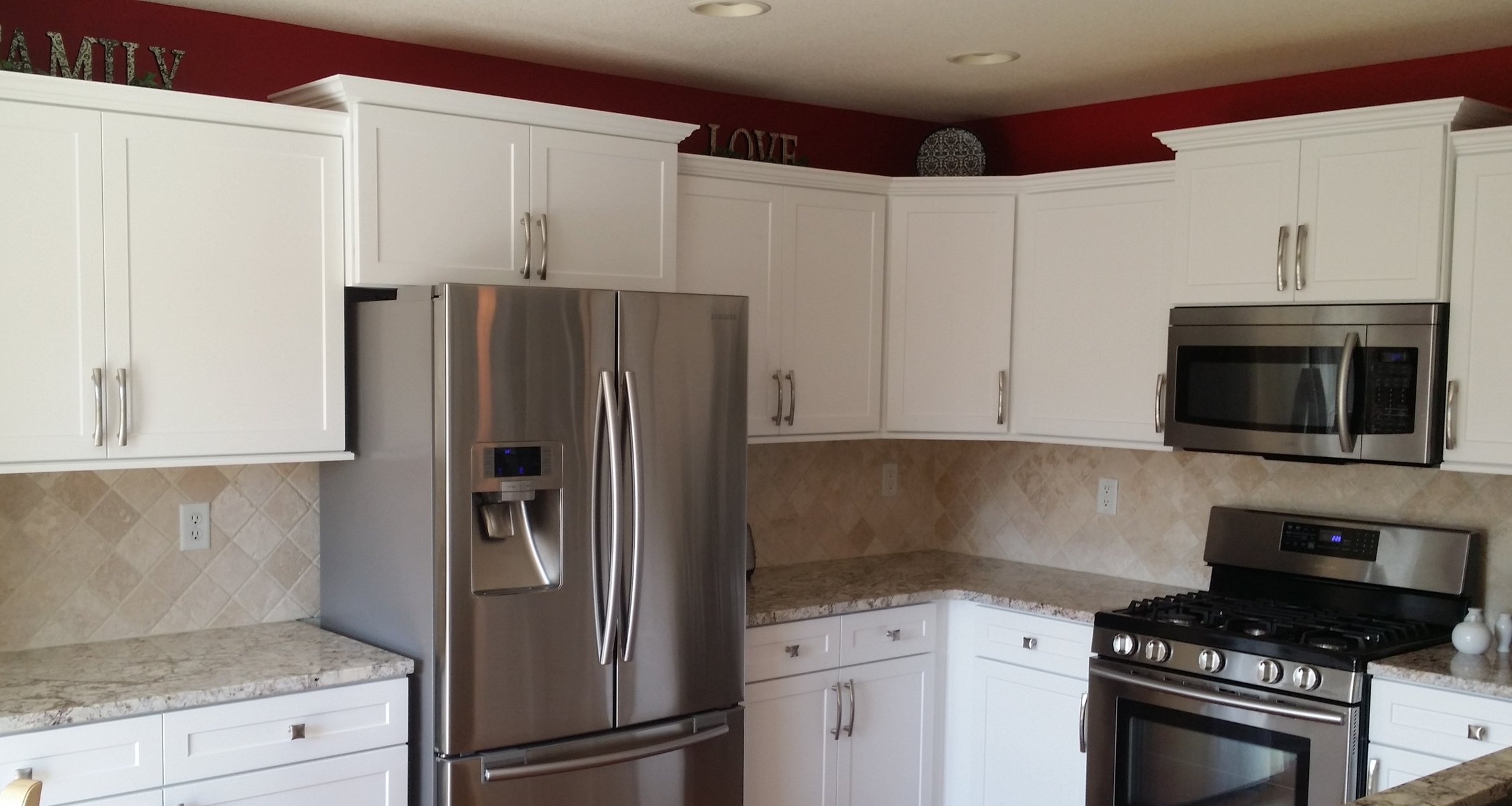 Replacing standard cabinet sizes with a larger cabinet above the microwave and or fridge can give a simple kitchen a much more dramatic look if you have space for it. This photo also features crown moulding, under cabinet trim, and full overlay spacing.