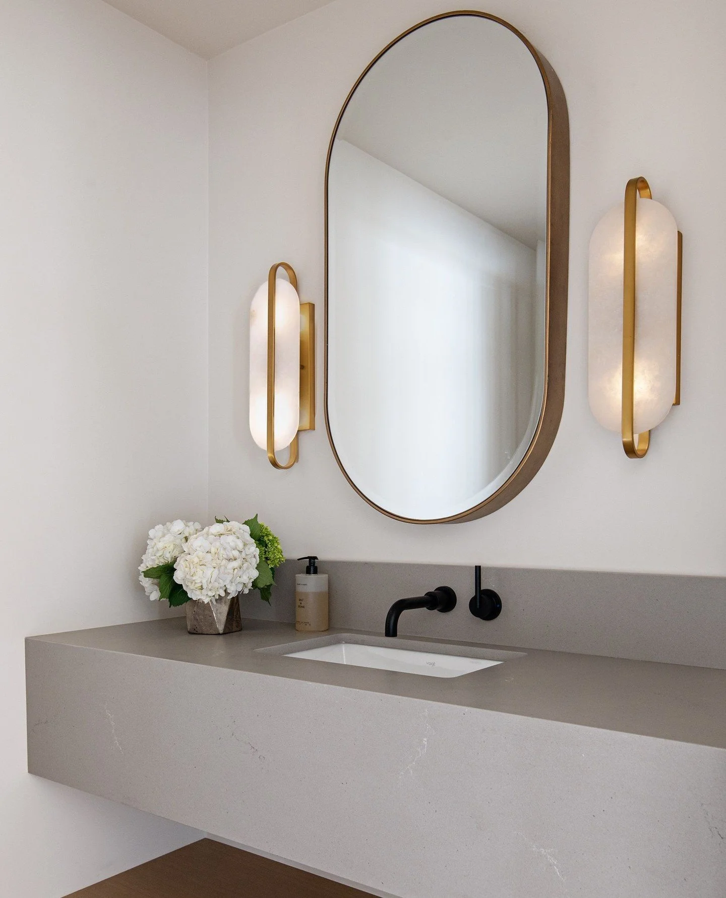 Designed with simplicity in mind, this custom floating vanity stretches wall to wall in a new main floor powder. It's hard to see, but there is a gorgeous floating oak shelf just beneath for fresh hand towels and extra tp (hidden in a box or basket).