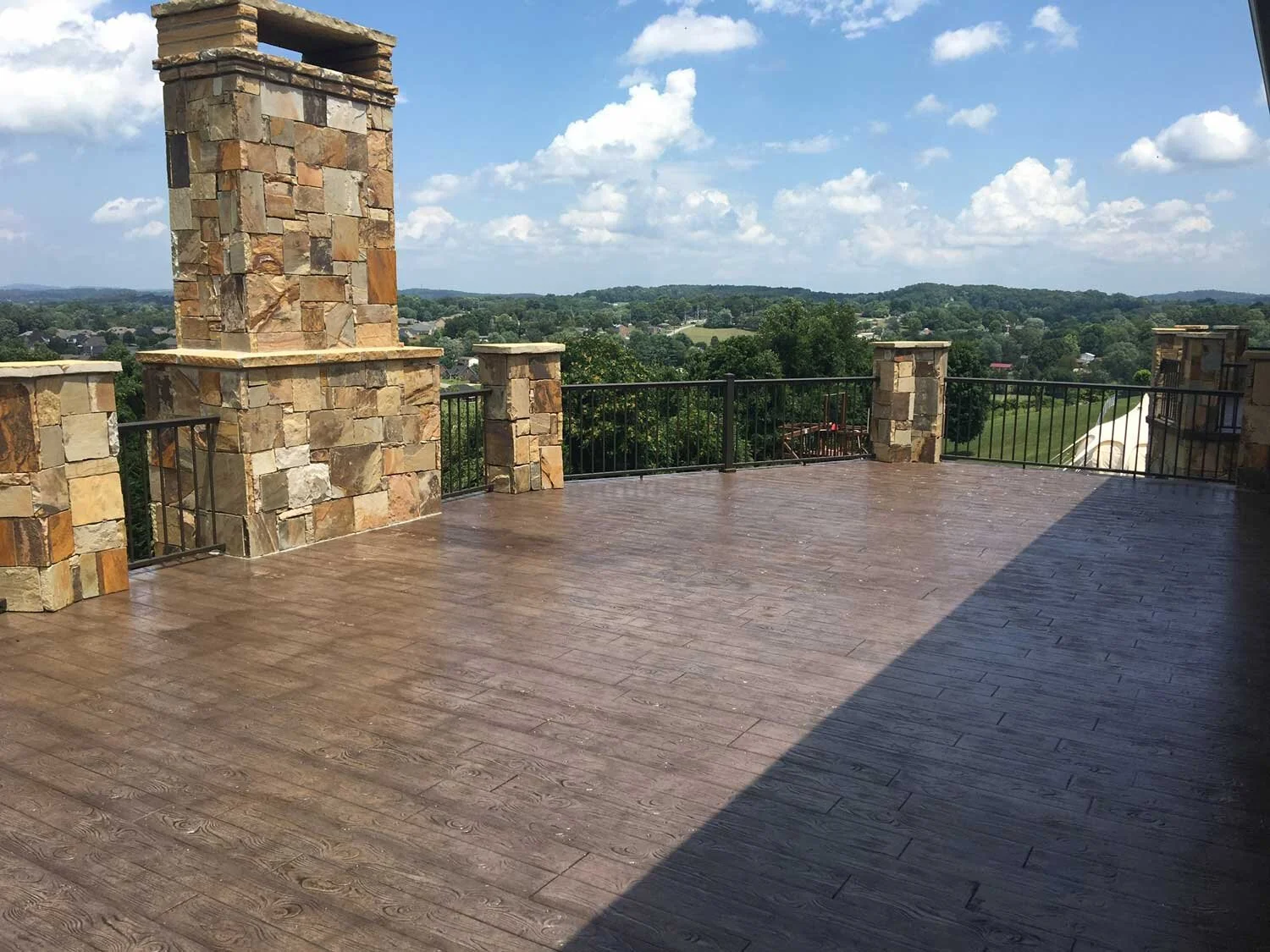Elevated concrete deck featuring classic wood plank stamp and desert tan integral color, and walnut antique-it