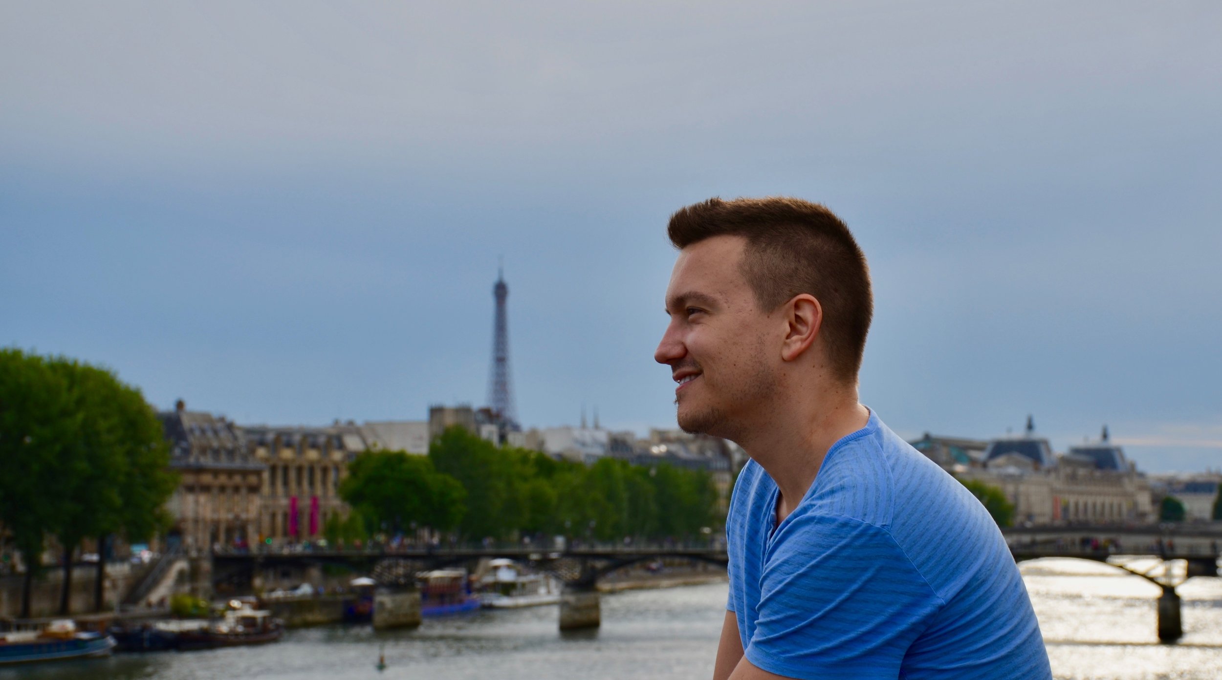 Corey de Tar sitting alongside the Seine River - Boston Organ Studio