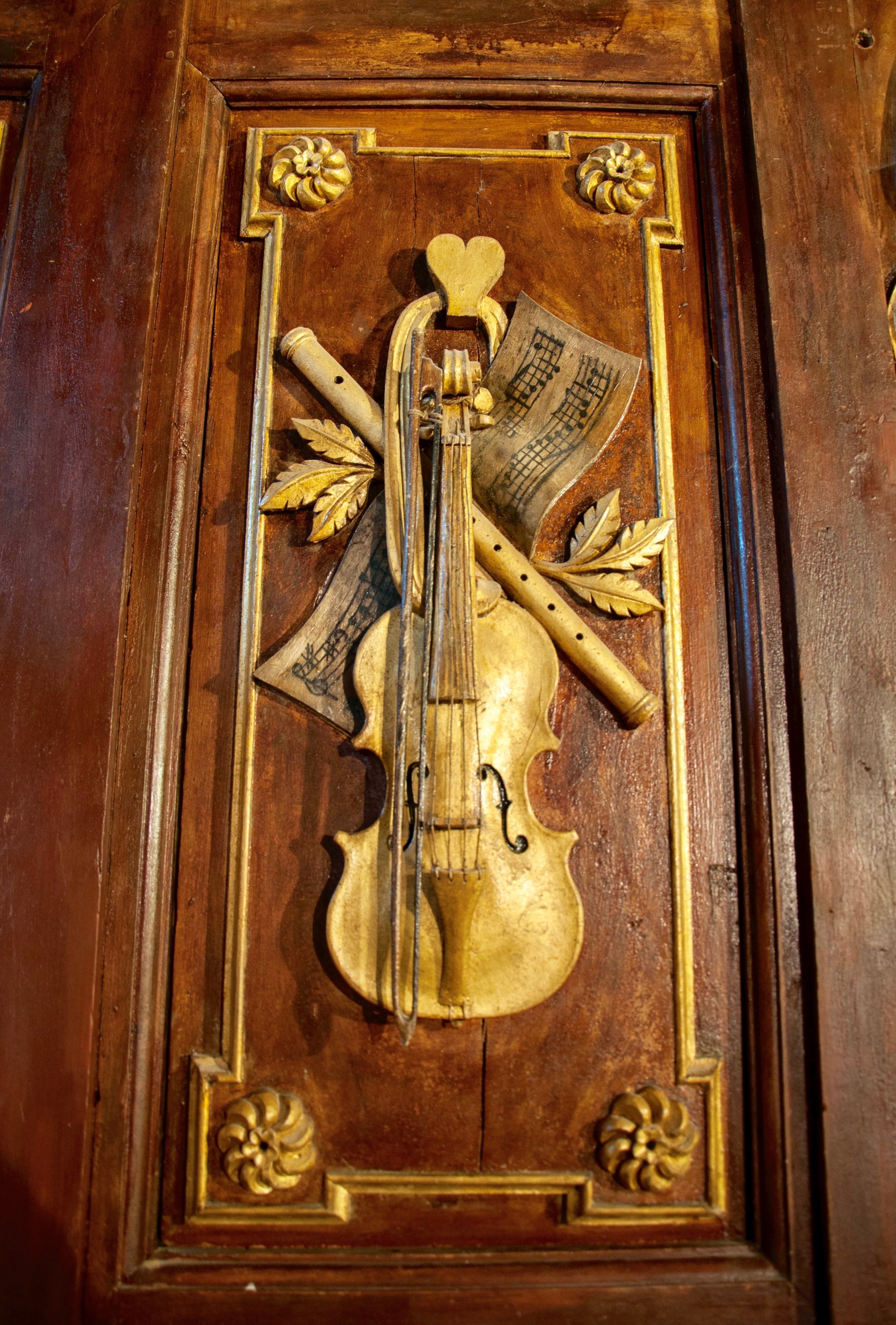 Detail of the case work -- an actual violin affixed to the organ case in St Felix-Lauragais