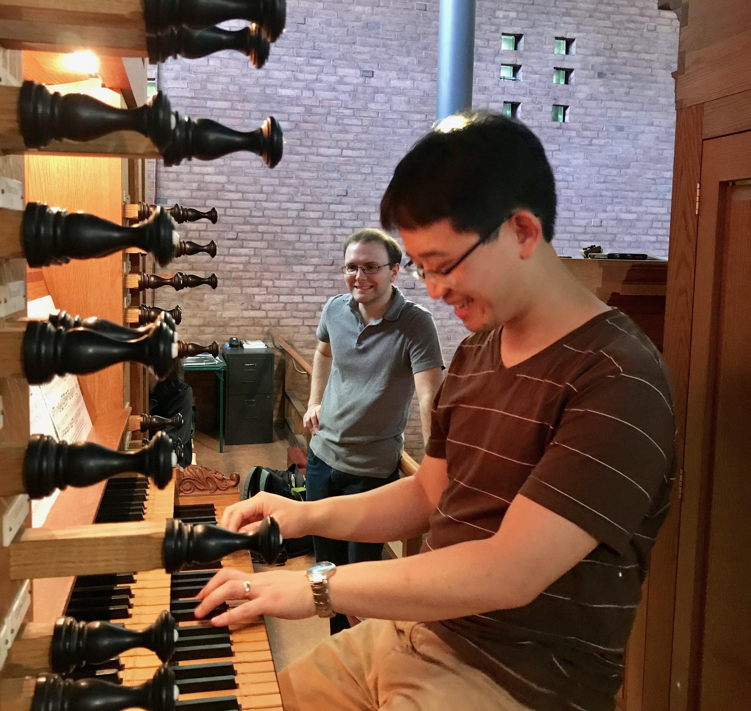  Organist Emerson Fang plays at First Lutheran Church, as Jonathan Wessler looks on. Boston Organ Studio.&nbsp; 