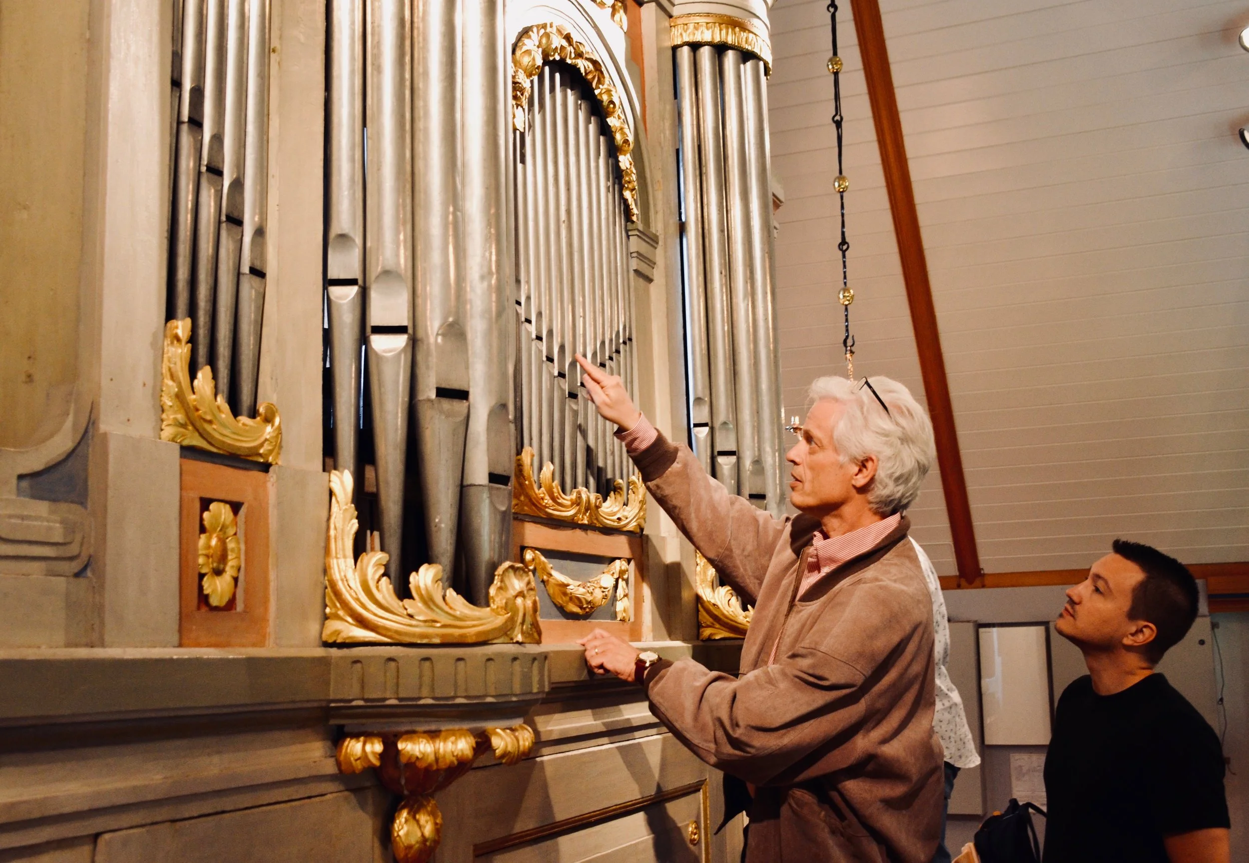Hans Davidsson points out features of the 1783 instrument in Jonsered, Sweden. 