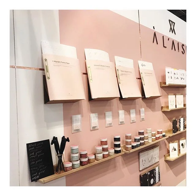Day 2 @ny_now and a closer look at calligraphy corner and our updated calligraphy workbooks. Translucent pink covers and brass binding. We&rsquo;re in the handmade section, stand 1240b. We&rsquo;d love to say hi if you&rsquo;re visiting! #nynow #nationalstationeryshow #nss