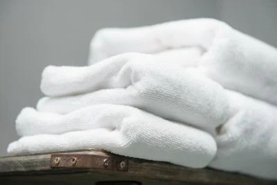 white towel placed on shelves in bathroom of hotel, fabric