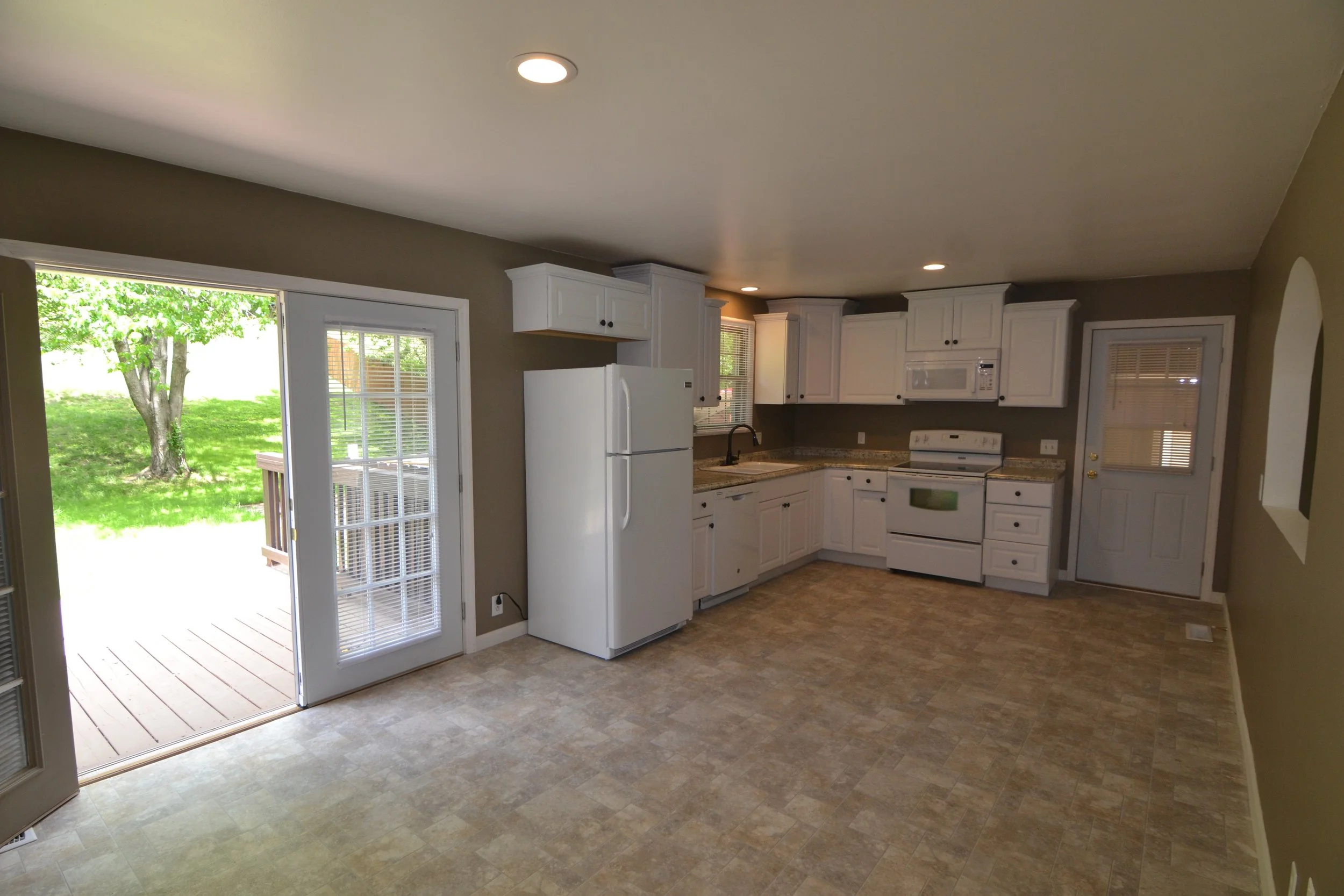 Spacious kitchen with New double french doors leading to 10x30 ft Deck overlooking beautiful Landscaped back yard with Privacy fence