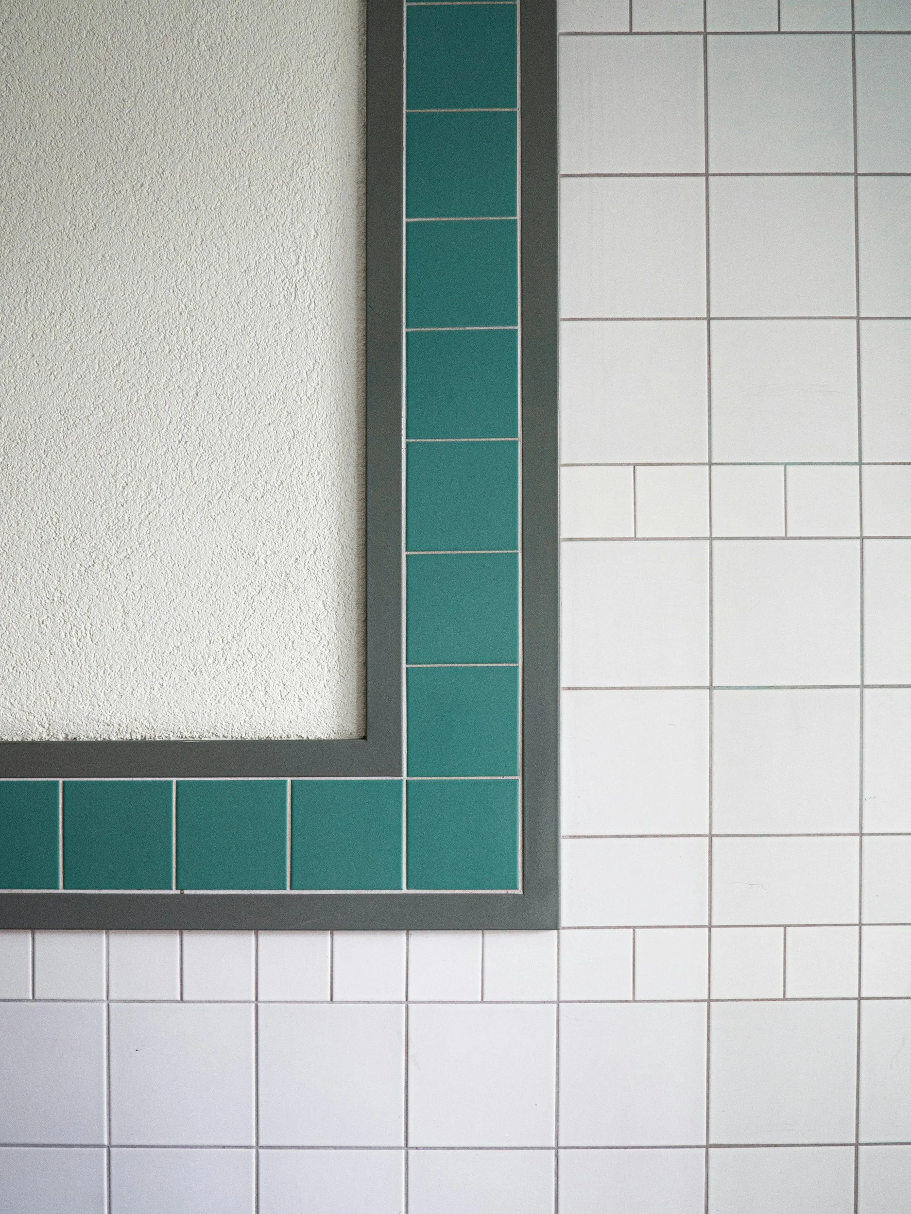 Precisely aligned wall tiles with a contrasting green tile border