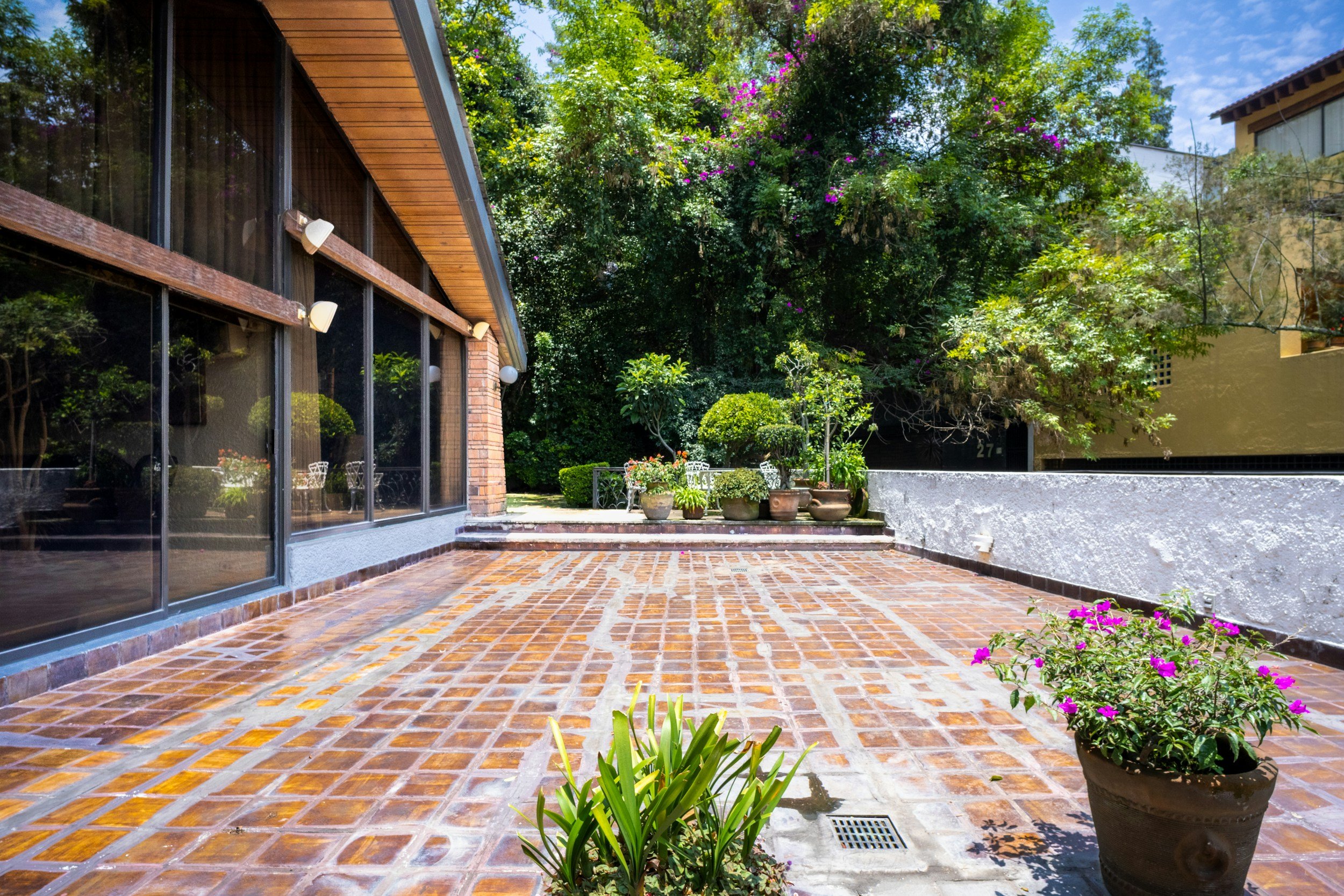 Tiled outdoor courtyard flowing from the house into a garden