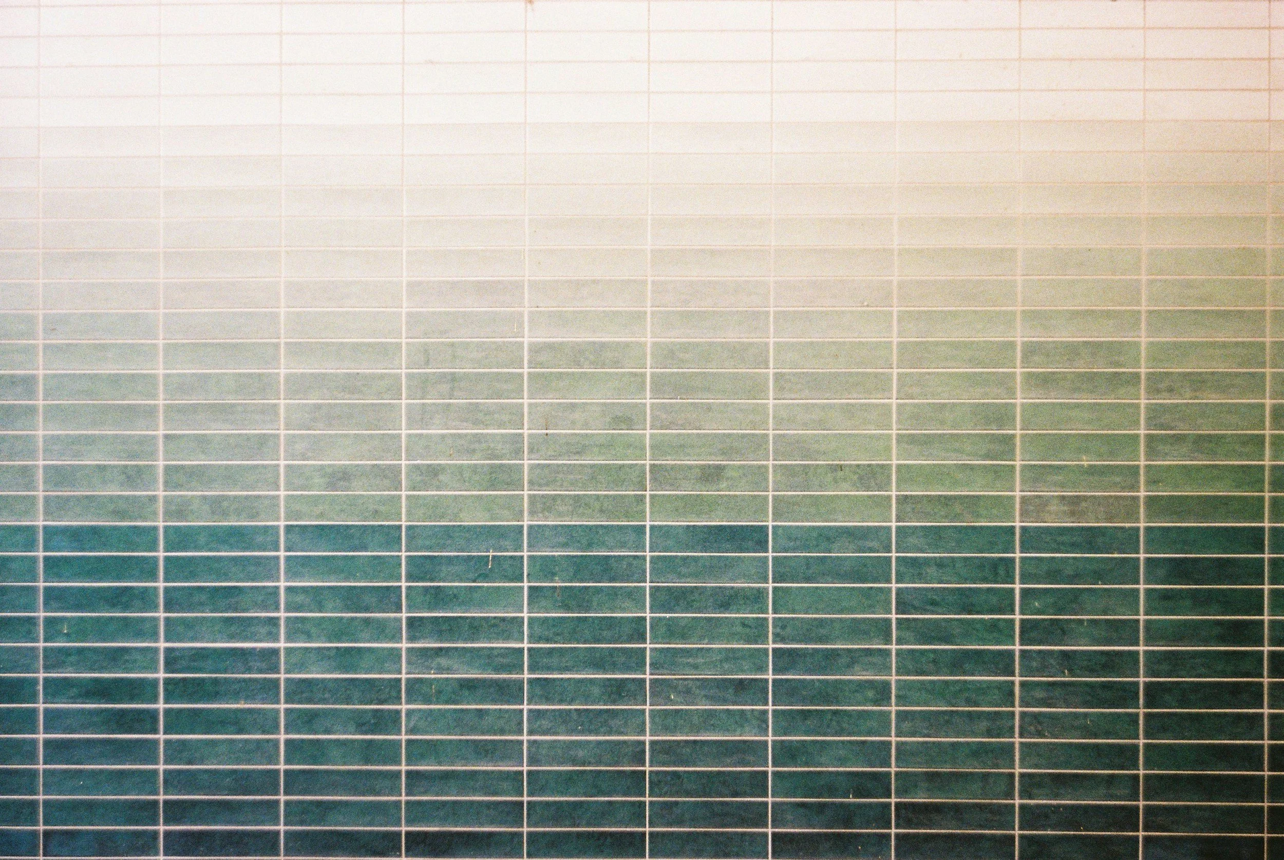 Kitchen splashback of slim stacked tiles in soft green and cream