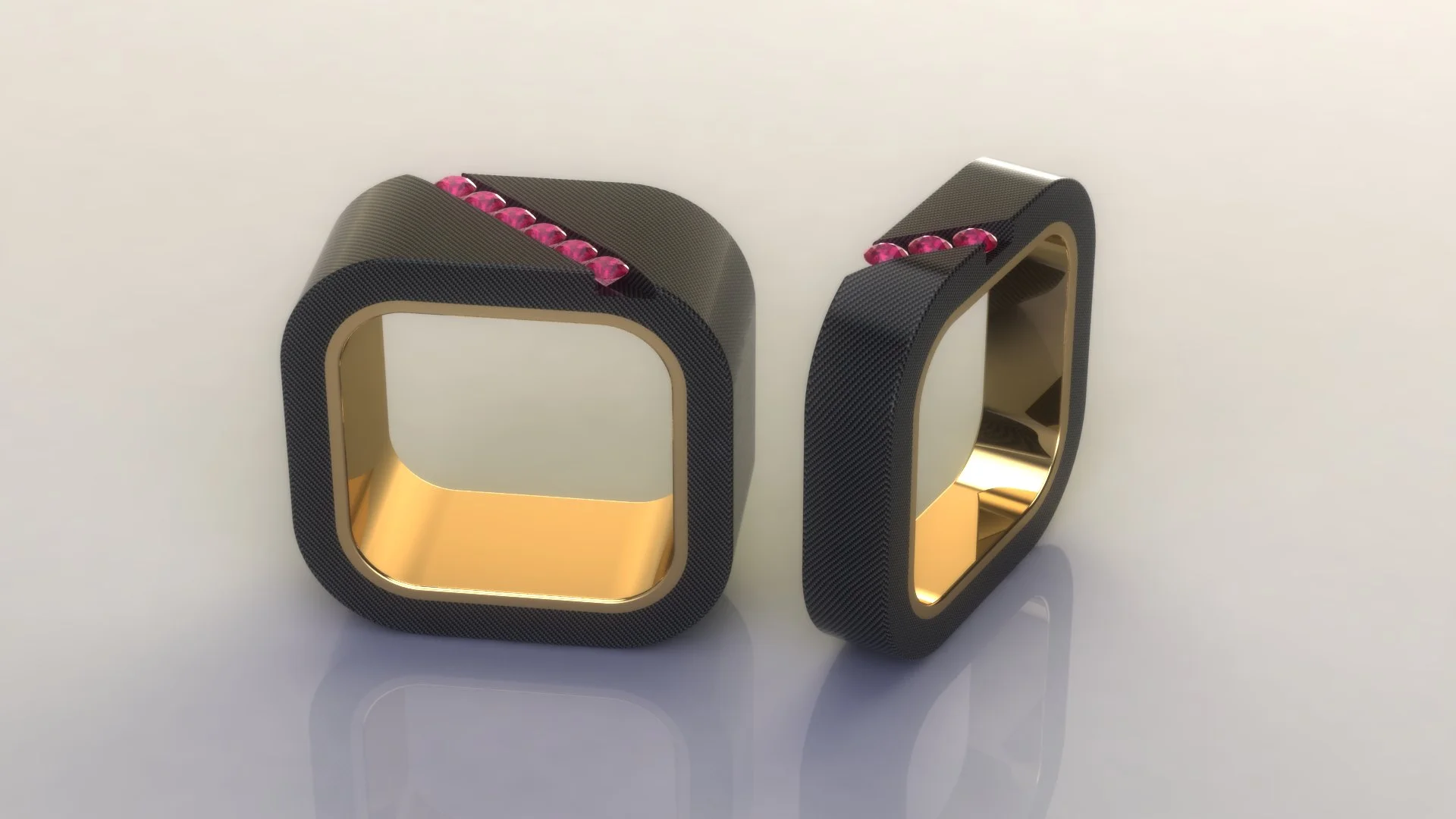Mens wedding bands in black carbon fiber and 18k yellow gold , and just a few pink sapphires for a splash of color. 