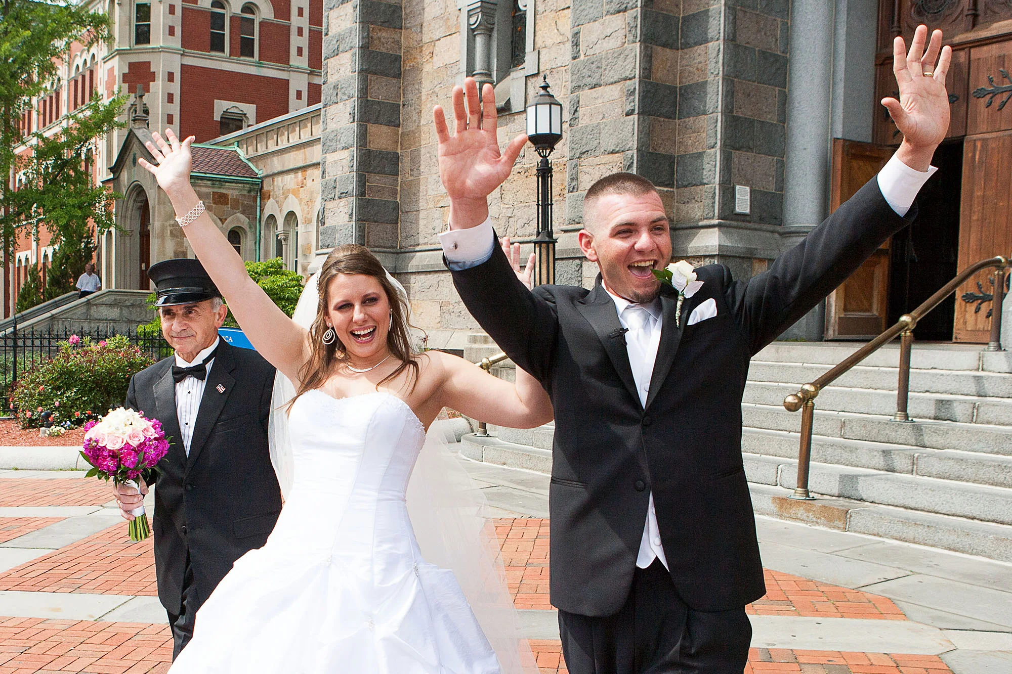 Bride and Groom waving outside church in Boston, MA. Westchester Wedding Photographer