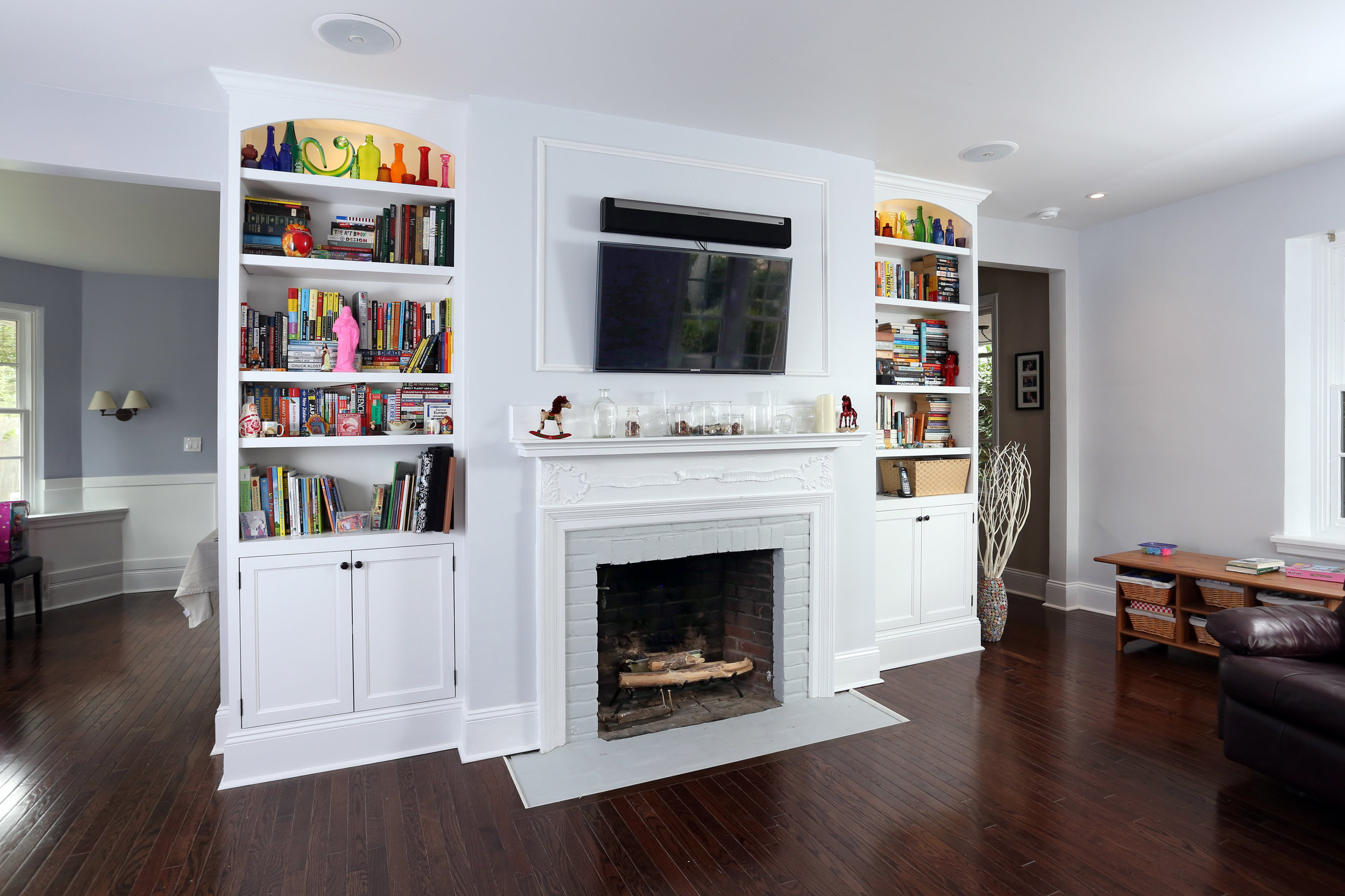  This pair of cabinets sits in the front room of the house.&nbsp;They also feature inset flat panel doors and oil rubbed bronze hardware. Each unit flanking the fireplace has an existing recessed overhead light incorporated into it. The client instal