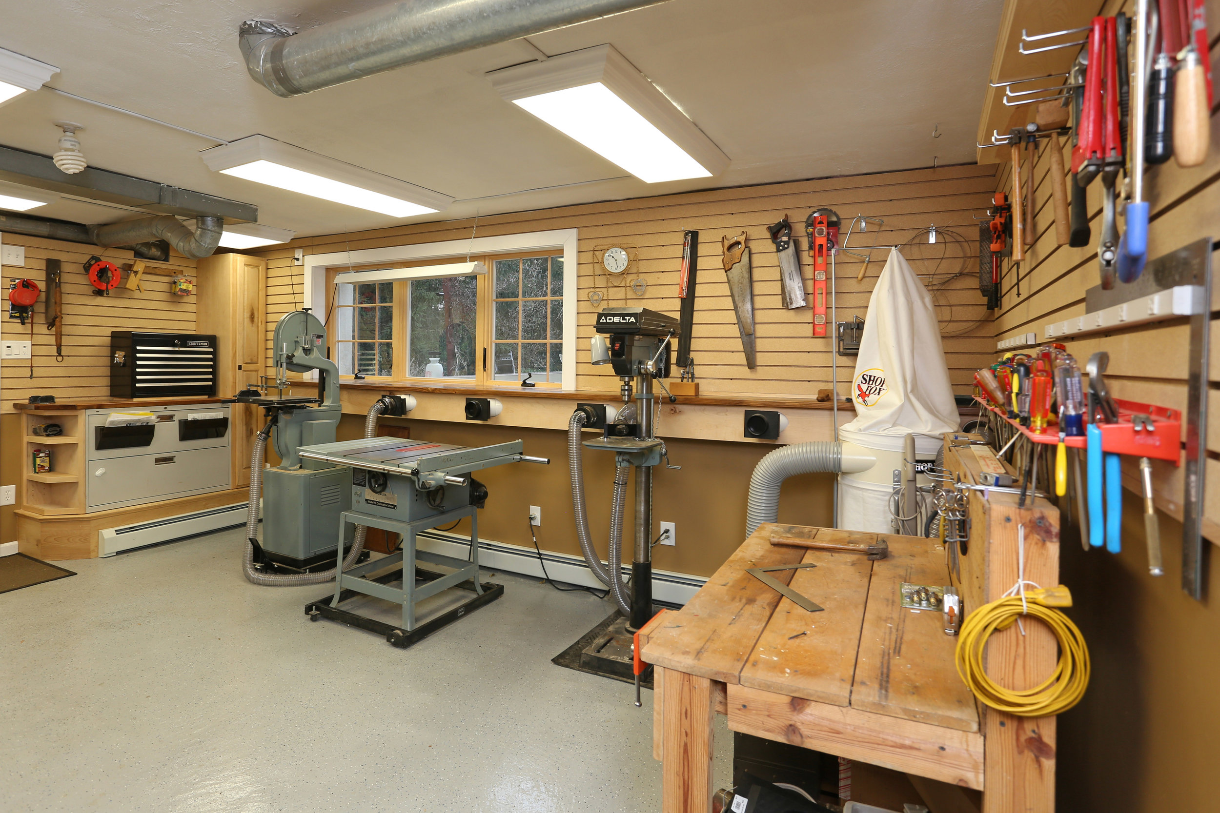  I added slatwall panels to the upper portion of all the walls to create more hanging storage for tools. I also added new baseboard heaters and custom cabinetry. 