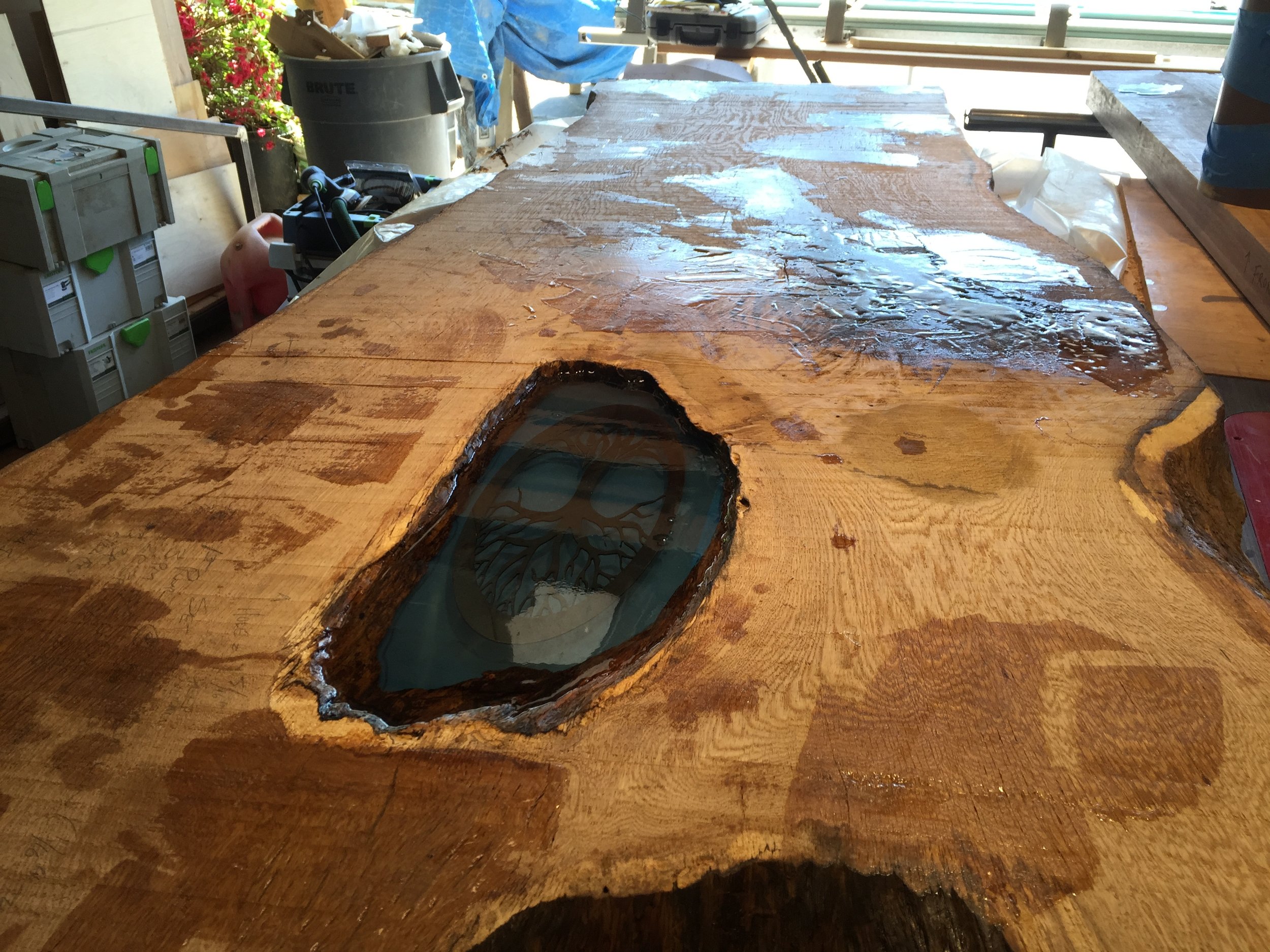  The client had a tree of life emblem she wanted embedded in the hole, so after I closed the bottom off with plexiglass, I installed the emblem in the middle of multiple layer of crystal clear epoxy. 