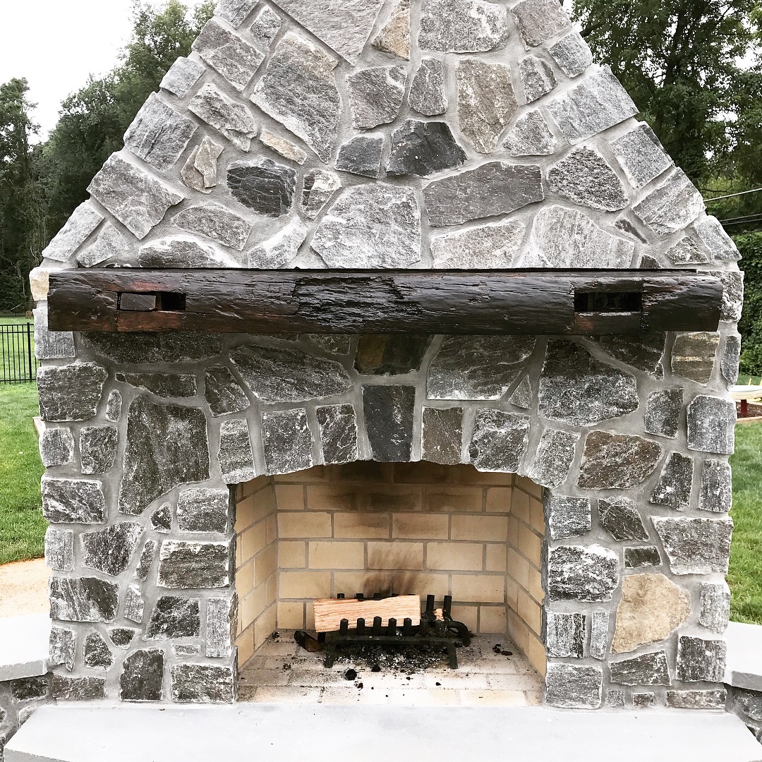  The finished beam installed on the new outdoor fireplace. The two pockets on the front face are original mortises that include the original draw bore pegs that were used to hold the tenon of a mating piece snugly in place. A portion of one of those 