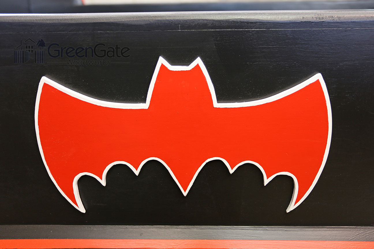A closeup of the Bat logo on the side rail of the bed.