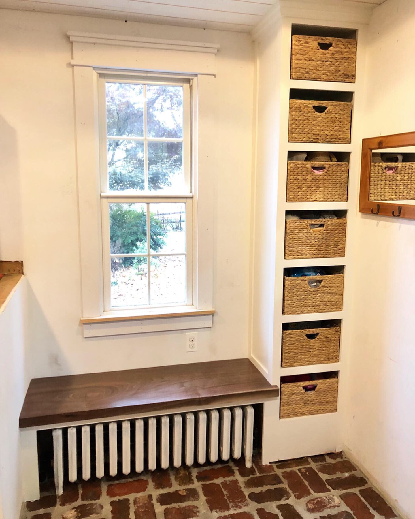  While I was putting in the lockers, I also finished up this taller shelving unit I had made previously for the other side of the room. Using a cutoff from the locker bench top, I put in a matching black walnut seat over our radiator. 