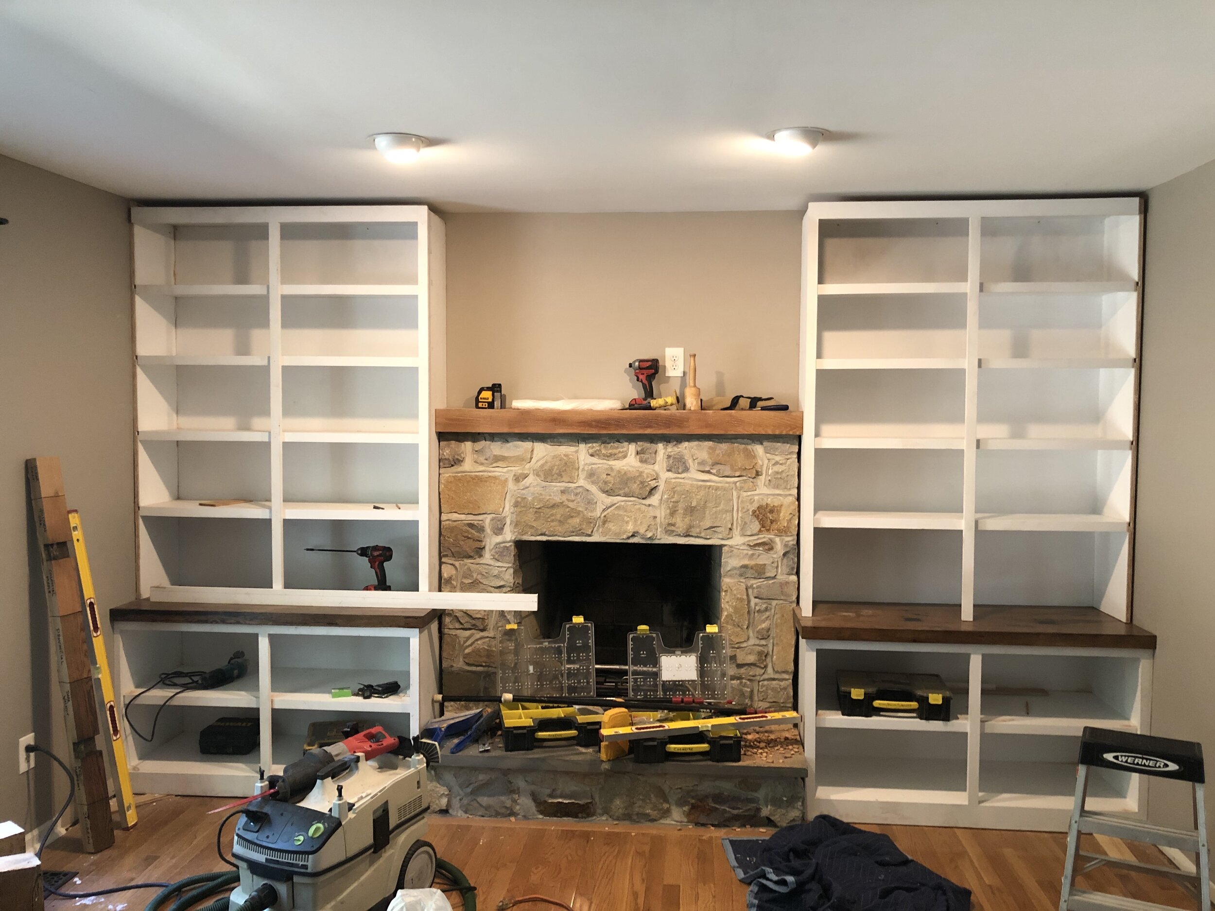  Fitting the upper cabinets was done very carefully to align with the cabinets below as well as fit to the existing fireplace stonework. The mantle was cut down to line up with the sides of the new upper cabinets exactly.  