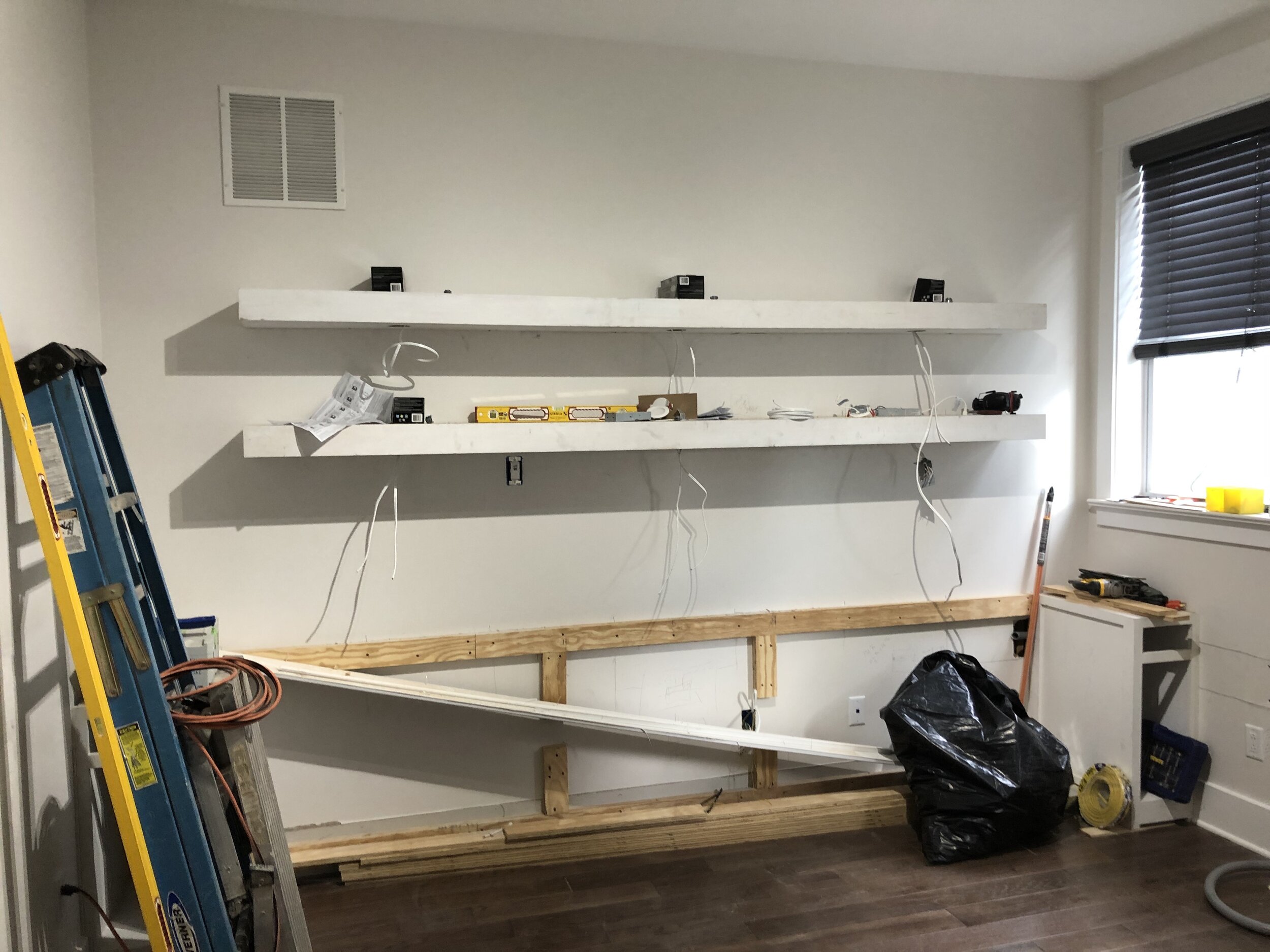  The design called for floating shelves above the desk with built-in lights, and three lower cabinets at the ends of the desktop to allow for maximum leg-room underneath. Here you can see the lower cabinets on the far right and (somewhat obscured by 